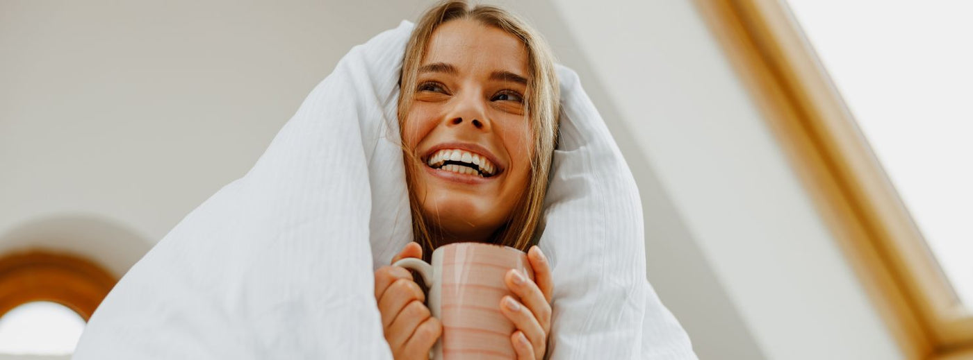 Meisje in bed met mok