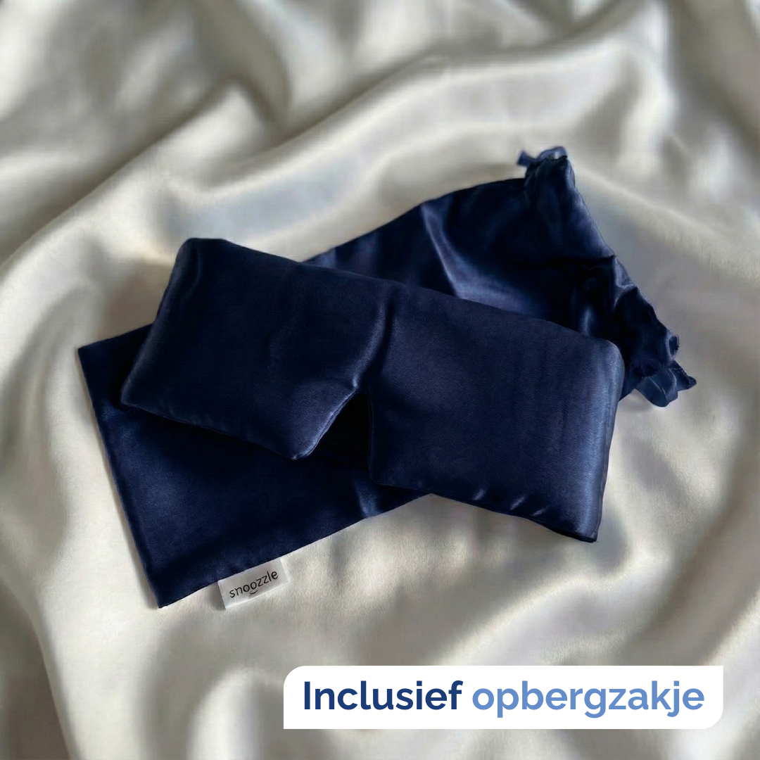 Zijden slaapmasker blauw met zakje op witzijden dekbed