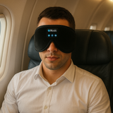 Man in een vliegtuig met bluetooth slaapmasker