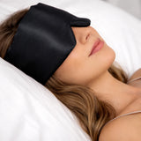Sfeerfoto slapende vrouw met zwarte zijden slaapmasker in bed