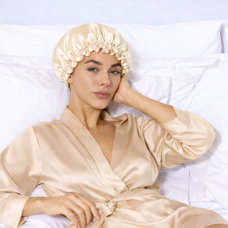 Vrouw in beige badjas met beige zijden bonnet op hoofd
