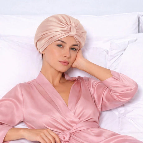 Vrouw in roze badjas met roze zijden bonnet op hoofd