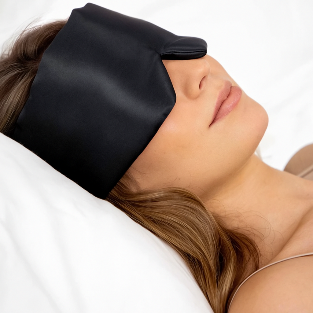 Sfeerfoto slapende vrouw met zwarte zijden slaapmasker in bed