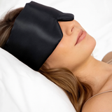 Sfeerfoto slapende vrouw met zwarte zijden slaapmasker in bed