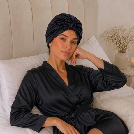 Vrouw met zwarte bonnet aan het poseren in bed
