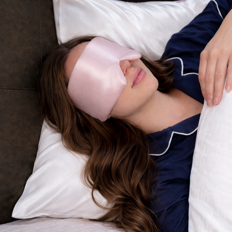 Vrouw liggen op zijden kussensloop wit met slaapmasker zijden roze