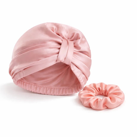 Bundel roze bonnet met roze scrunchie op witte achtergrond