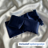 Zijden slaapmasker blauw met zakje op witzijden dekbed