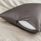 Grijs zijden kussensloop met ritssluiting op een bed